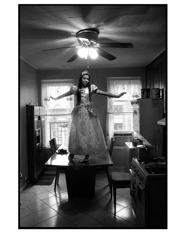 A portrait of my daughter, Alicia. She is posing on top of her grandmother’s kitchen table, dressed in her Halloween costume.